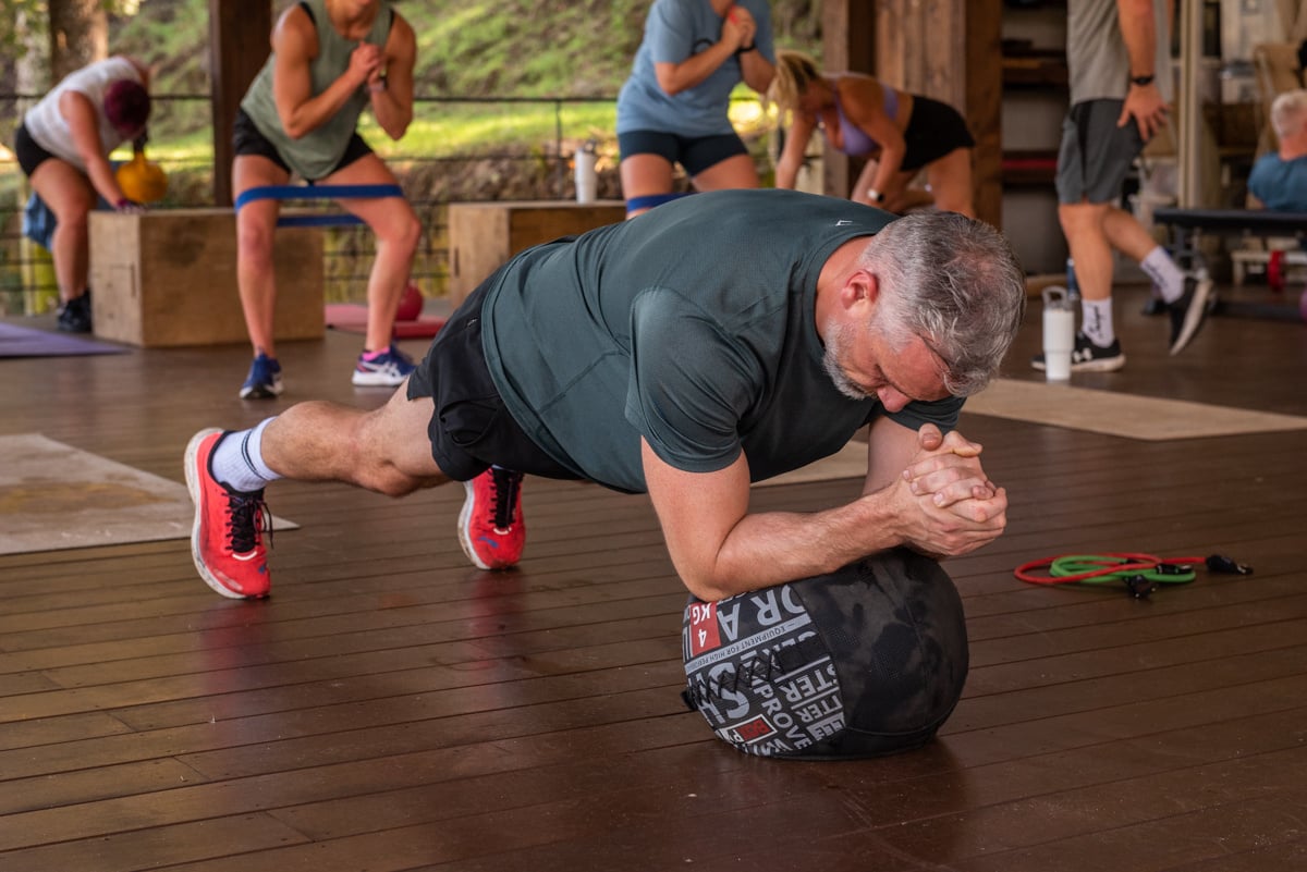 A personal trainer demonstrating how to plank using a ball